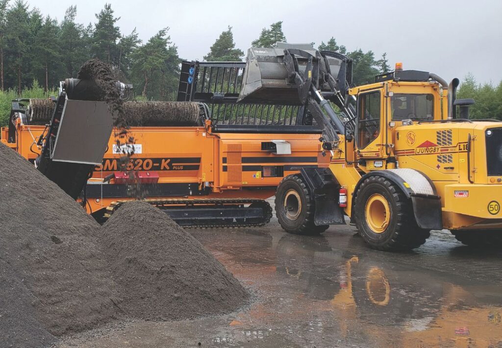 A trommel screen processing treated soil.