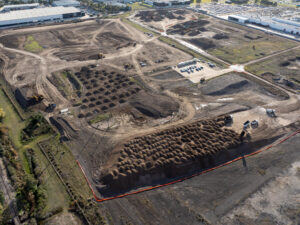 Aerial view of a large soil treatment site with rows of stockpiles staged for mixing.