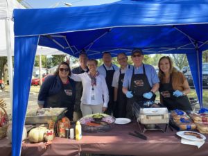 Carus leadership serves food to employees at parking lot cookout