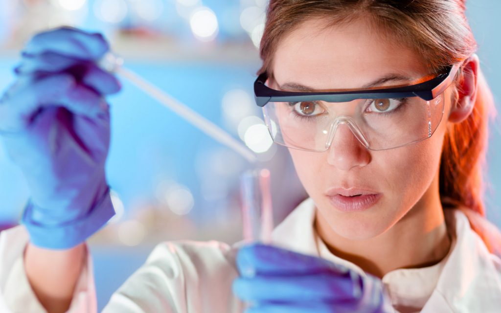 Women scientist focused on adding liquid to test tube